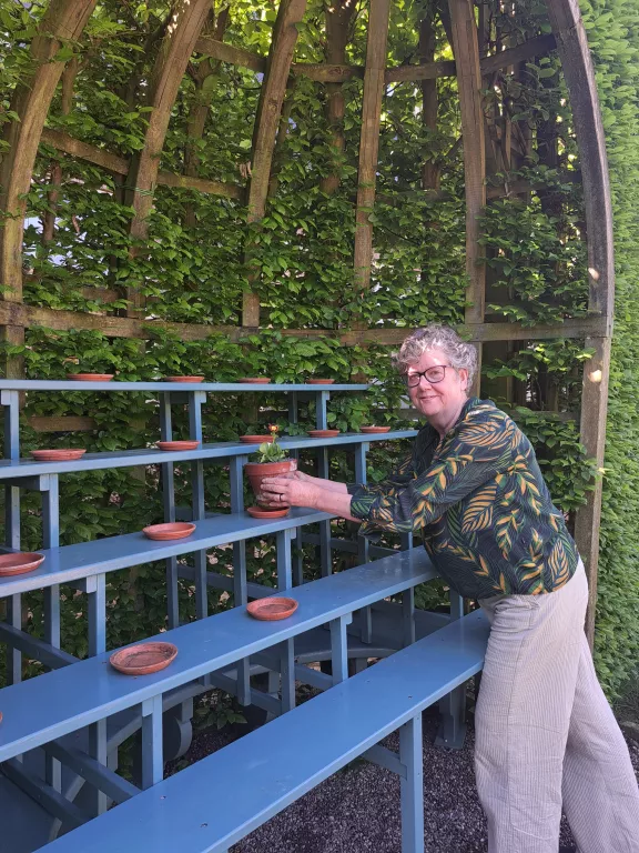 Aurikeltheater met conservator die de plantjes neerzet
