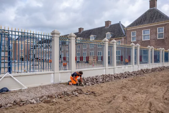 Klinkertjes worden gelegd voor het hek van Paleis Het Loo