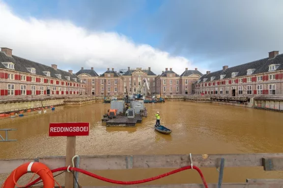 De voorkant van Paleis Het Loo onder water tijdens de verbouwing