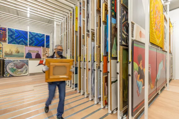 A man holds a painting in the CC NL painting collection