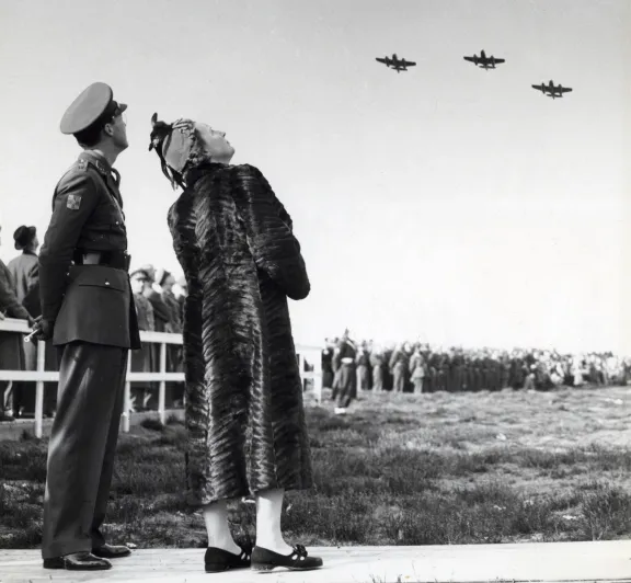 Prins Bernhard en koningin Juliana kijken naar gevechtsvliegtuigen, historische zwart wit foto