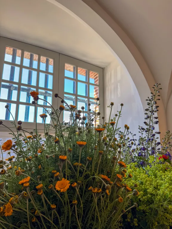 Raam met raamwerk en grote bos veldbloemen ervoor