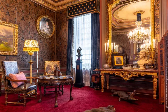 Zitkamer prins Hendrik met stoelen, spiegel en rode tapijten vloer
