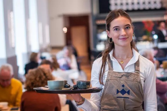 Een serveerster met dienblad in de balzaal klaar om te serveren