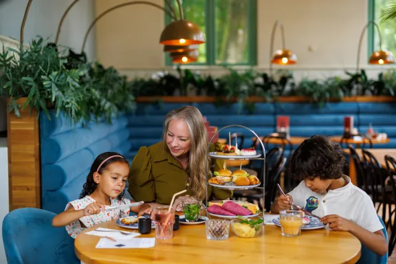 Een moeder met haar kinderen geniet samen van de high tea in de prins Hendrik garage