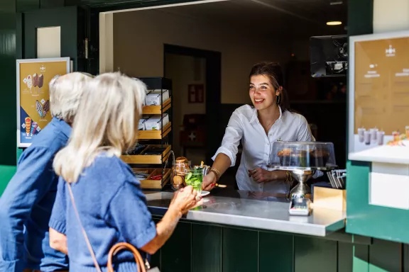 People getting a drink from a hospitality worker at the kiosk at Paleis Het Loo