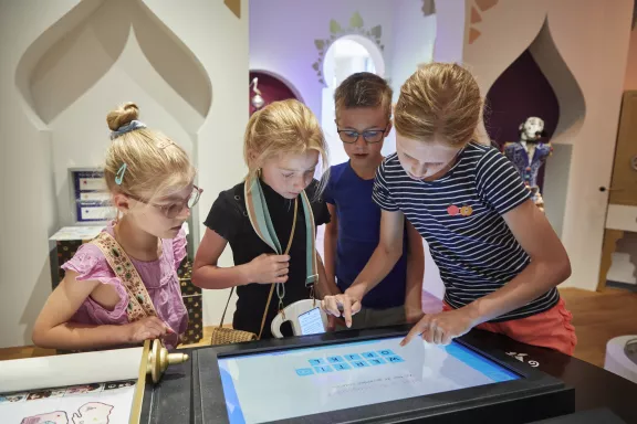 Kinderen werken samen en lossen problemen op bij het bureau van wereldzaken in het Juniorpaleis