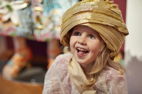 Meisje kijkt blij nadat ze zich als prinses heeft verkleed