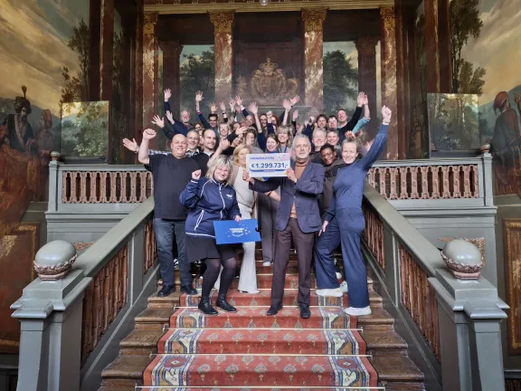groep mensen met cheque op de grote trap