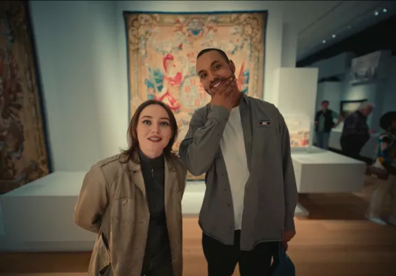 Twee mensen kijken naar De Oranjes tentoonstelling