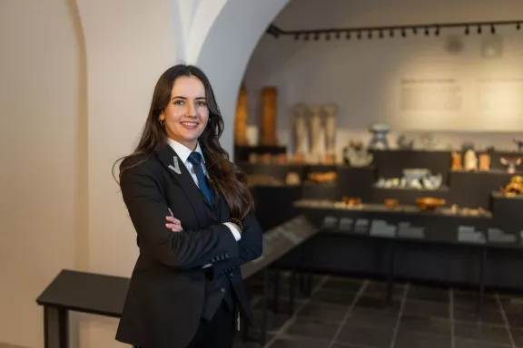 Een beveiliging medewerkster van Paleis Het Loo lacht terwijl ze de archeologische collectie van Paleis Het Loo bewaakt