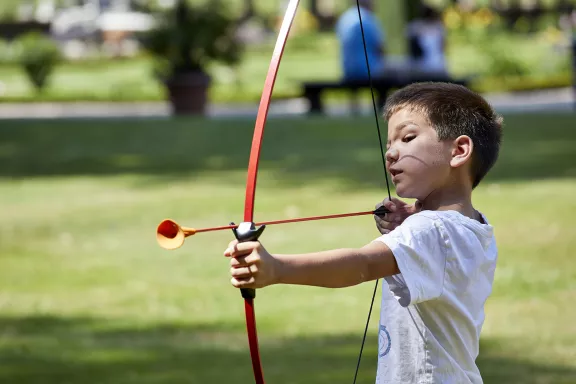 Kleine jongen spant boog om te schieten