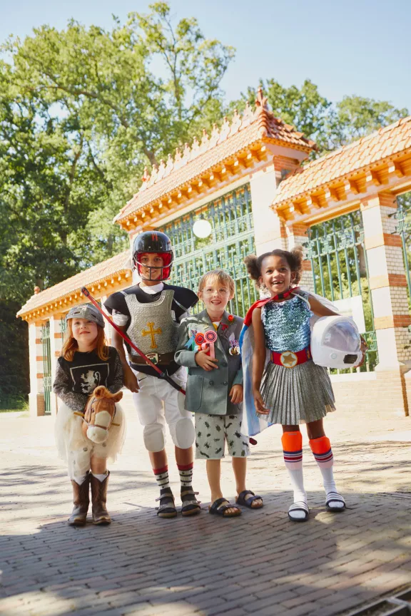 Children dressed as princes and princesses in front of the gate at the stables square