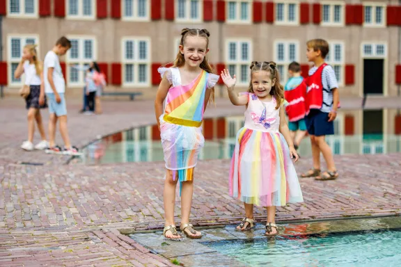 Kinderen die spelen met water voor het paleis