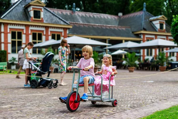 Kinderen racen op de racelaan op het stallenplein.