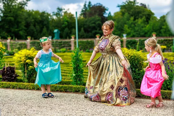 Kinderen worden de hofdans geleerd in de tuinen van Paleis Het Loo