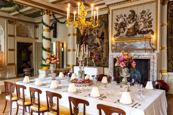 De tafel in de nieuwe eetzaal is gedekt in kerstsferen met boeketten
