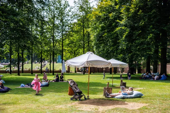 Summer days at Paleis Het Loo with people relaxing in the chill meadow