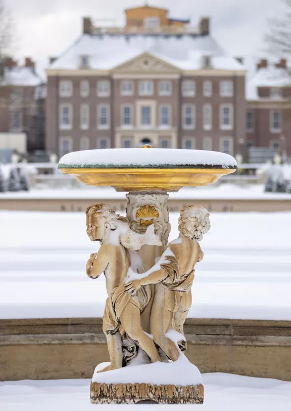 Het paleis op de achtergrond met de fontein in de voorgrond in de besneeuwde tuin