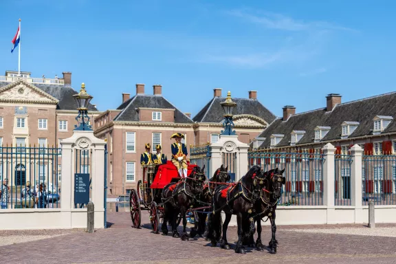 Een koets voorgetrokken door paarden met koetsiers op de koets rijdt de ganzevoet op