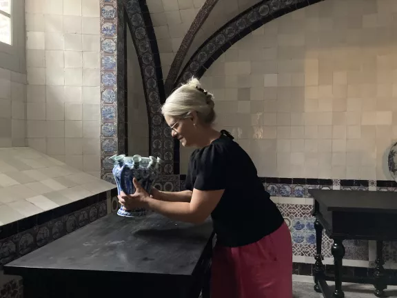 Kristin Duysters zet Delfts aardewerk op een tafel in het keukenkeldertje