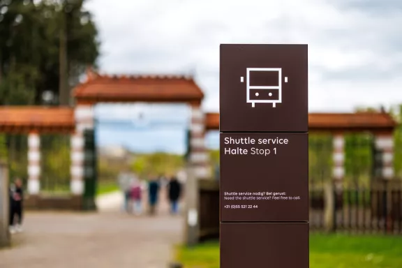 Een bordje van de shuttle service vanaf waar mensen de shuttle kunnen nemen van het stallenplein naar het paleis