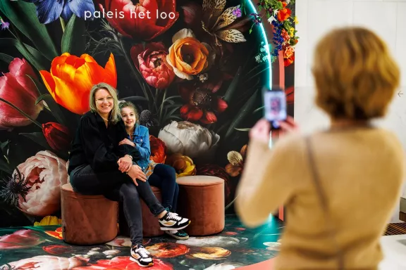Eine Mutter und ihre Tochter posieren an Blooms mit Blumen geschmücktem Selfie-Spot