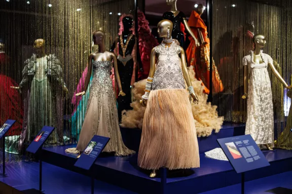 Van links naar rechts: een glinsterende avondjurk van de Chinese couture-ontwerpster Guo Pei, een zilverkleurige pasteljurk gedragen door Salma Hayek tijdens het Cannes Filmfestival in 2011 en de witte avondjurk met bloemenborduursel en bijpassend jasje ontworpen door Givenchy Couture en gedragen door Jennifer Lawrence