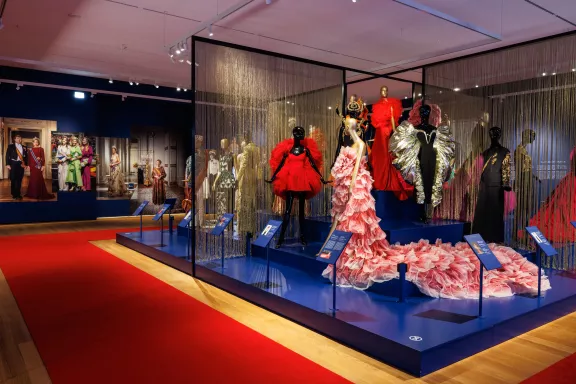 Verschillende jurken van links naar rechts: een rode minijurk ontworpen door Christian Siriano voor Lady Gaga, een Elie Saab jurk uit de '1001 Seasons'-collectie, gedragen door Heidi Klum en een opvallende zwarte avondjurk met volumineuze, gouden lamé mouwen van Daniel Roseberry voor Schiaparelli