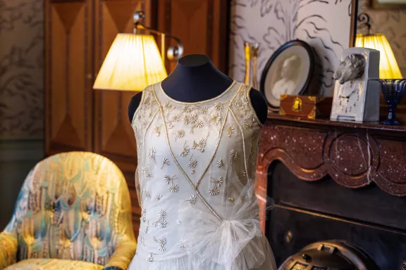 Avondjurk van prinses Juliana naar ontwerp van het Parijse modehuis Premet uit 1927, uitgevoerd in crèmekleurige tule en zijde met fijn borduurwerk