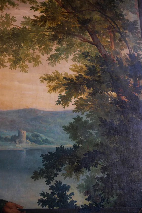Detail van schildering met rivieroever op de achtergrond en bomen op de voorgrond