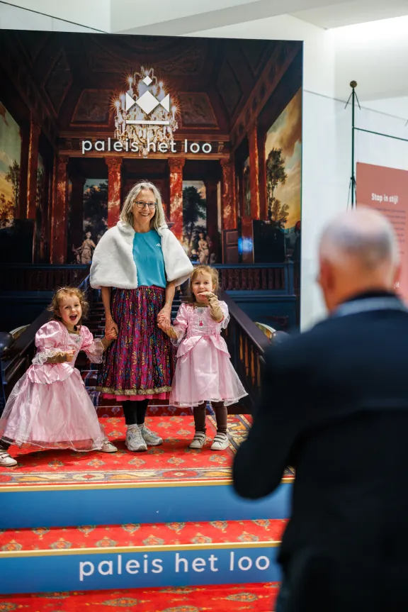 Eine Großmutter posiert mit ihren Enkelkindern vor dem Fotopunkt an der großen Treppe
