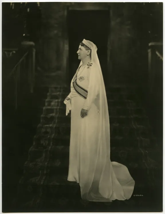 Wilhelmina poseert in witte rouwkleding op de grote trap na het overlijden van haar man prins Hendrik in 1934