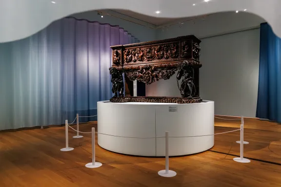 Grote bewerkt houten kast met figuren in de tentoonstelling uitgelicht: koloniale kast