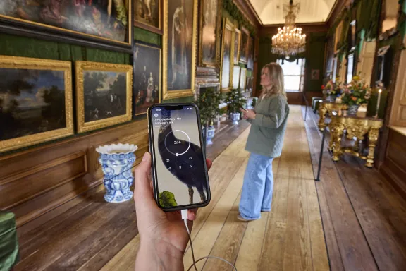 Ein in der Hand gehaltenes Telefon in einer Gemäldegalerie.
