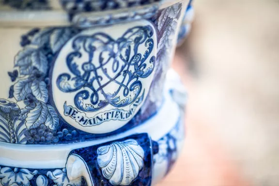 A Delft blue vase with the saying 'Je maintiendrai'