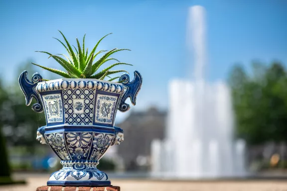 Delftsblauw aardewerk met een cactus en de Koningssprong op de achtergrond