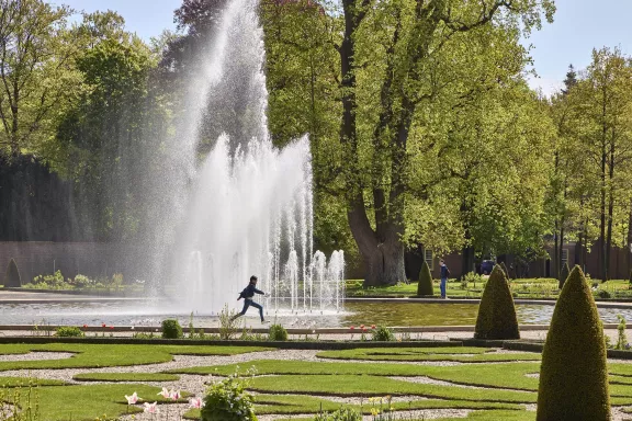 Ein Kind geht durch den oberen Garten vor dem Königsbrunnen